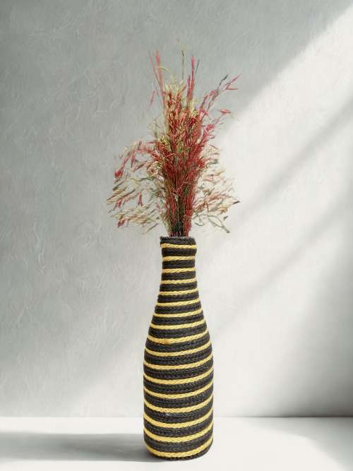 Handcrafted bottle vase wrapped in textured wool, featuring soft pampas grass — minimal modern home décor by Aduné