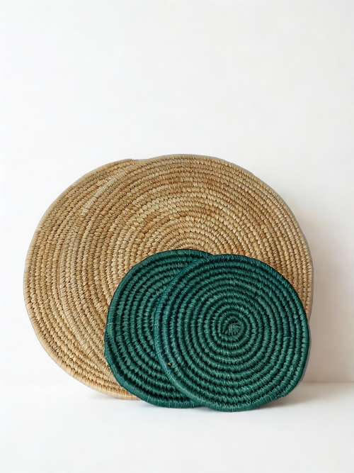 Beige handwoven placemats with green trivets styled on dining table. Natural fiber table set featuring two beige placemats and two green trivets. Minimalist table decor set in beige and green tones, handmade finish. Eco-friendly woven table accessories for elegant dining spaces.